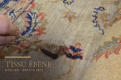 Détachage au pinceau, produit posé au point sur une tache brune d&rsquo;un tapis noué main, à l&rsquo;atelier Tissu Ébène