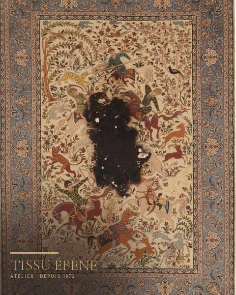 Tapis Ispahan à scène de chasse sur fond ivoire, large zone noircie et trouée au centre