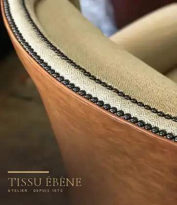 Fauteuil club regarni cuir et tissu, clous décoratifs posés à la main