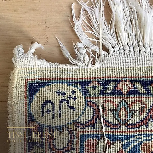 Frange de tapis effilochée, nœuds défaits à l&rsquo;extrémité, avant réparation